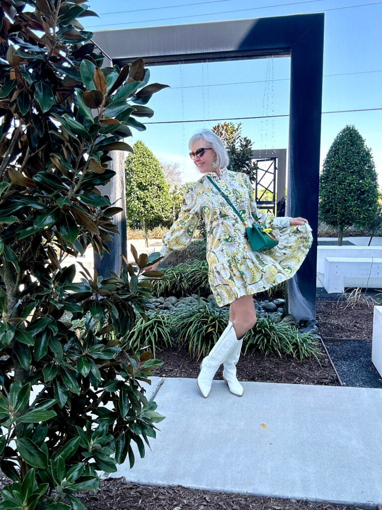 Sheree Frede in a white and yellow print dress wearing white cowboy boots