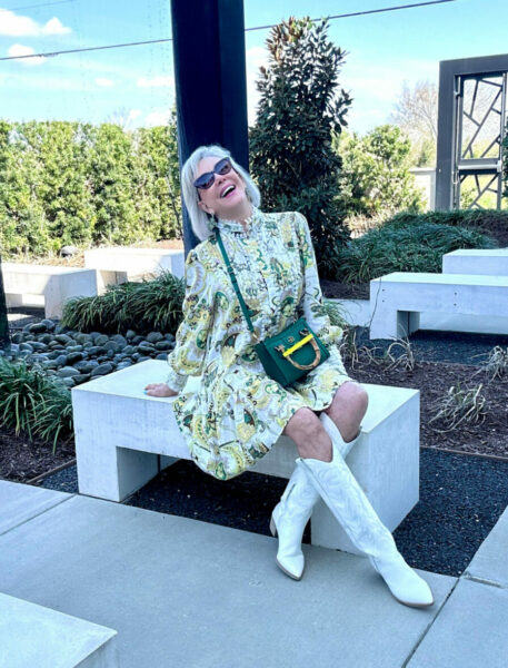 Sheree Frede celebrating in a white and yellow print dress wearing white cowboy boots