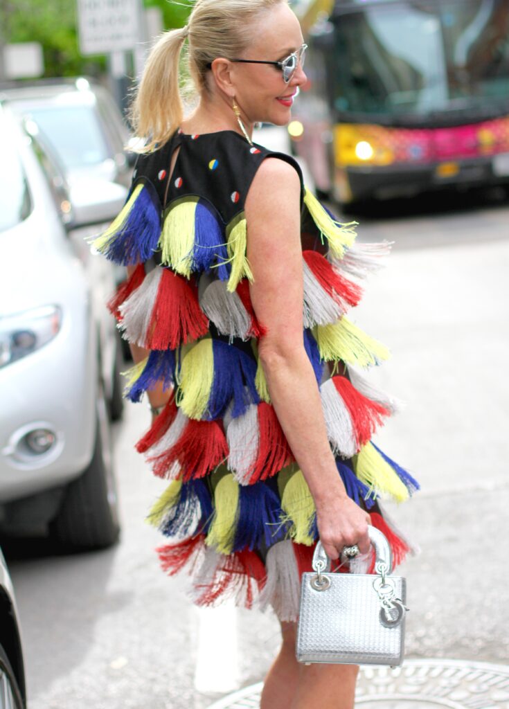 Sherree Frede wearing a pony tail and colorful fringe dress