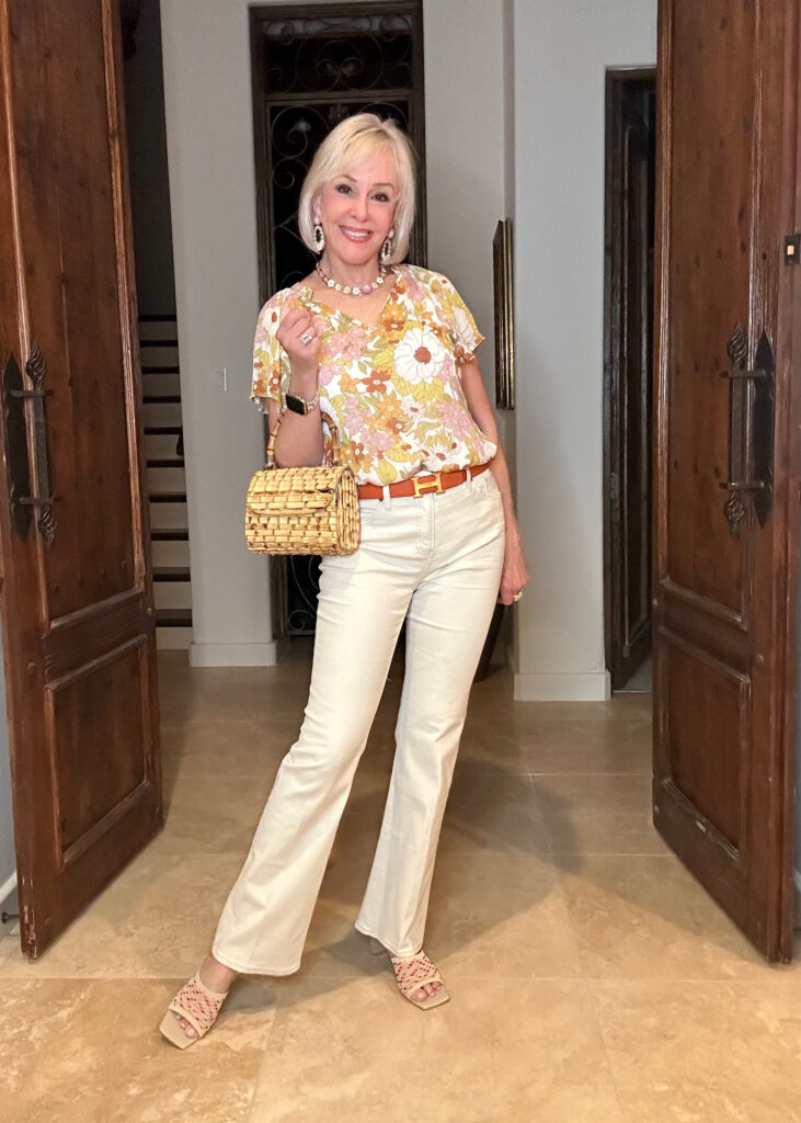 Sheree Frede Wearing a yellow floral top with flutter sleeves with off white flare jeans