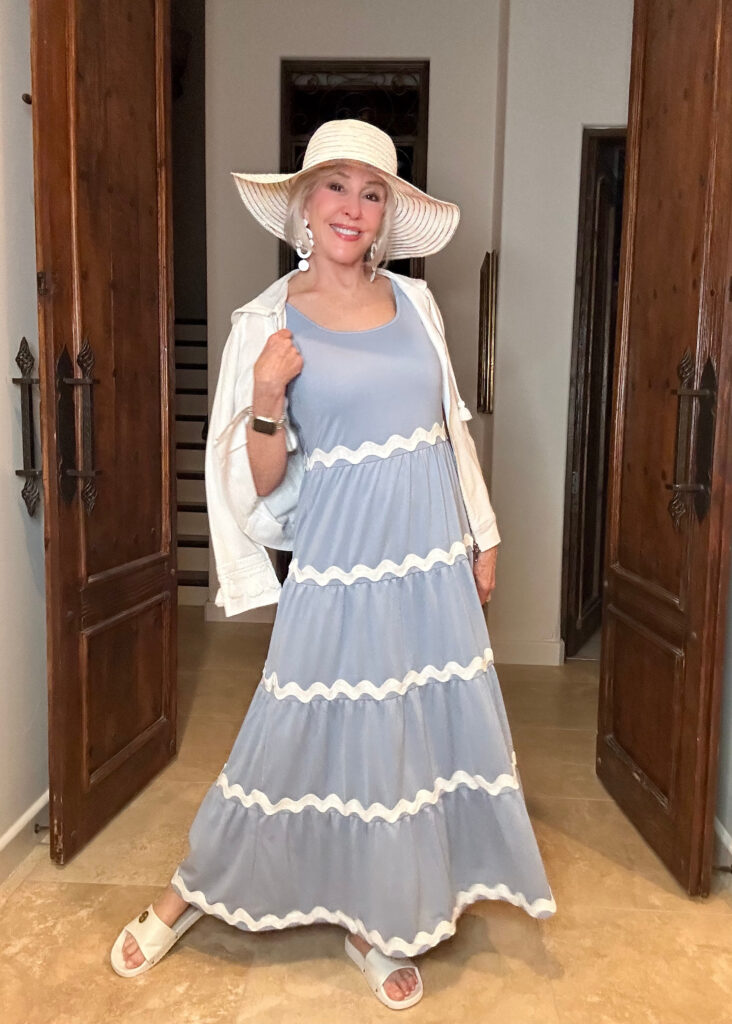 Sheree Frede Wearing a light blue maxie dress with white sweater and white hat
