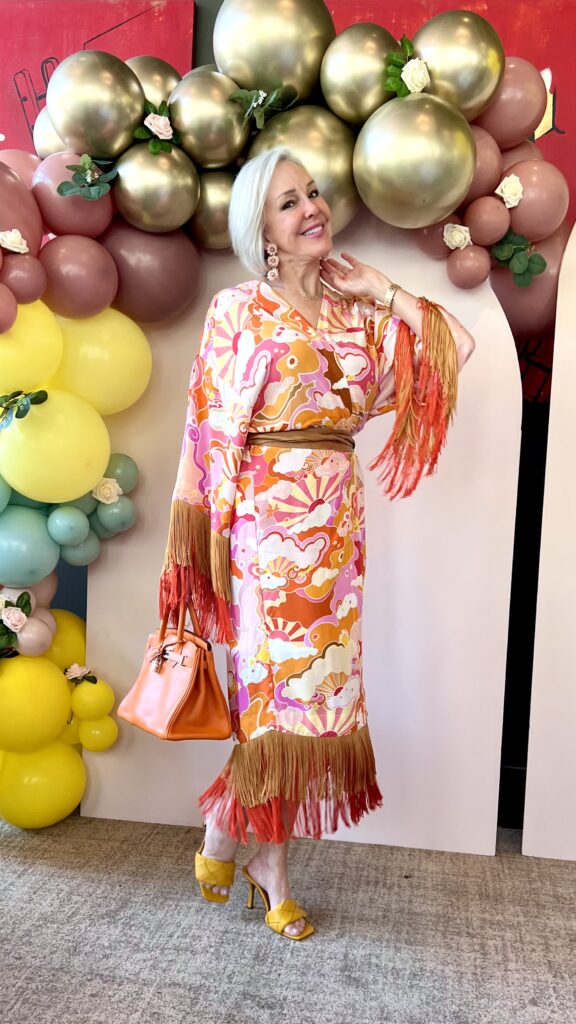 Sheree Frede surrounded by balloons wearing a wrap kimono with fringe
