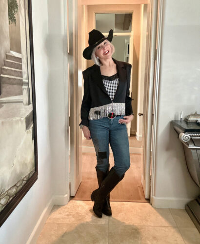 Sheree Frede of SheShe Show in black cropped blazer with rhinestone fringe, plaid cami, denim jeans, black knee high boots and black felt cowboy hat for western wear rodeo.