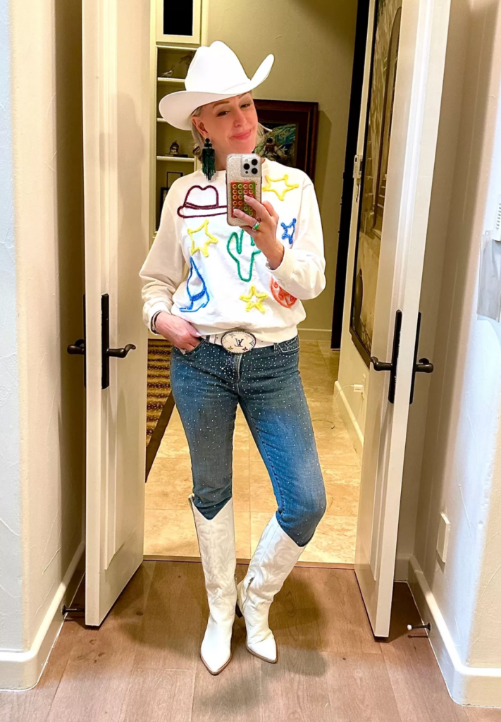 Sheree Frede of SheShe Show in white western sweatshirt, sparkly rhinestone jeans, white cowgirl boots, and white cowgirl hat