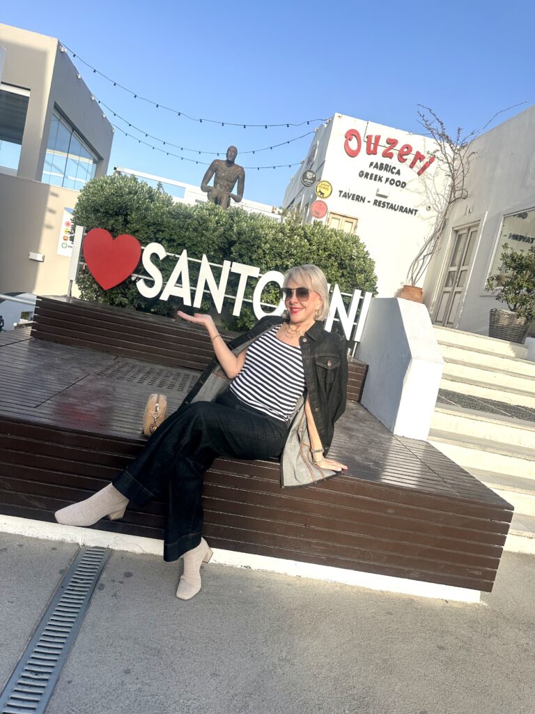 Sheree Frede sitting in front of the Santorini Sign