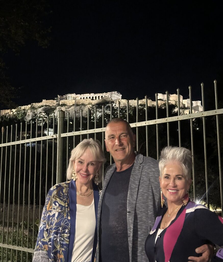 Sheree, Thanos and Shauna standing in front of the Acropolis in Athens, Greece