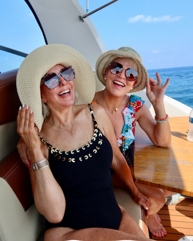 Sheree & Shauna wearing sun hats, sun glasses, and swimsuits