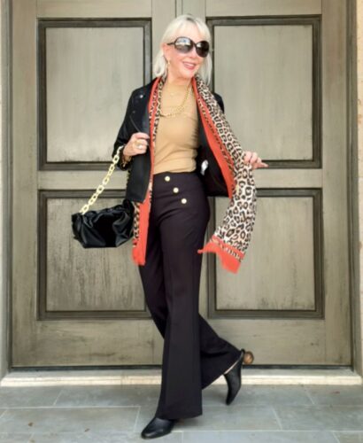 Neutral top paired with black pants with trending leopard scarf