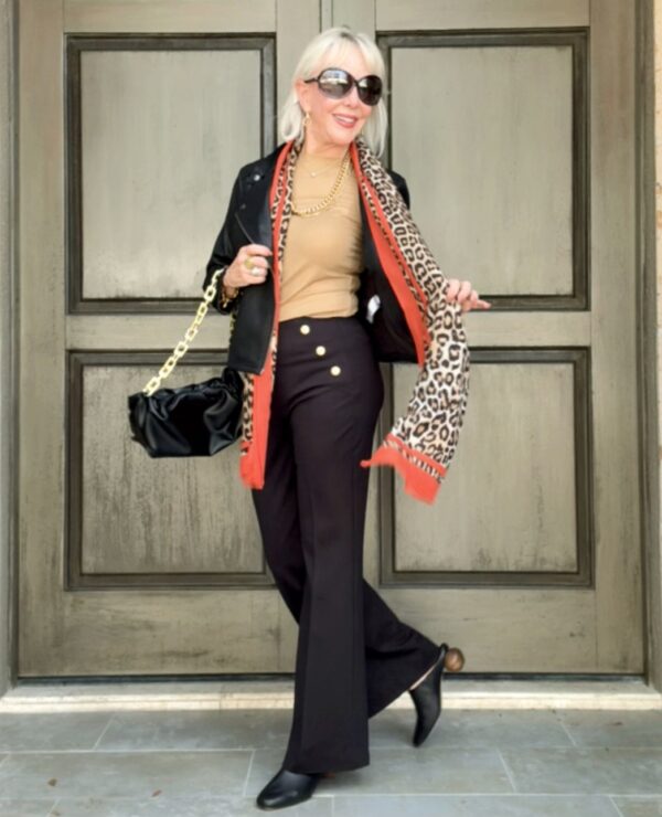 Neutral top paired with black pants with trending leopard scarf