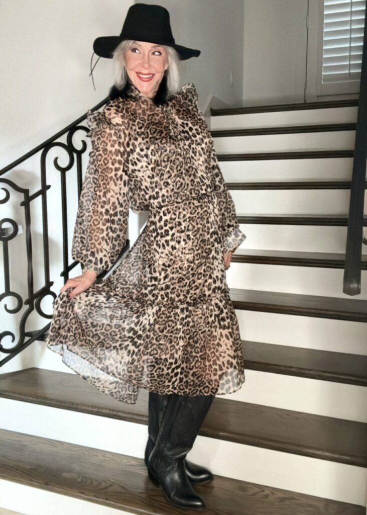 Sheree wearing a sheer leopard print dress with black Lucchese cowboy boots and black suede hat